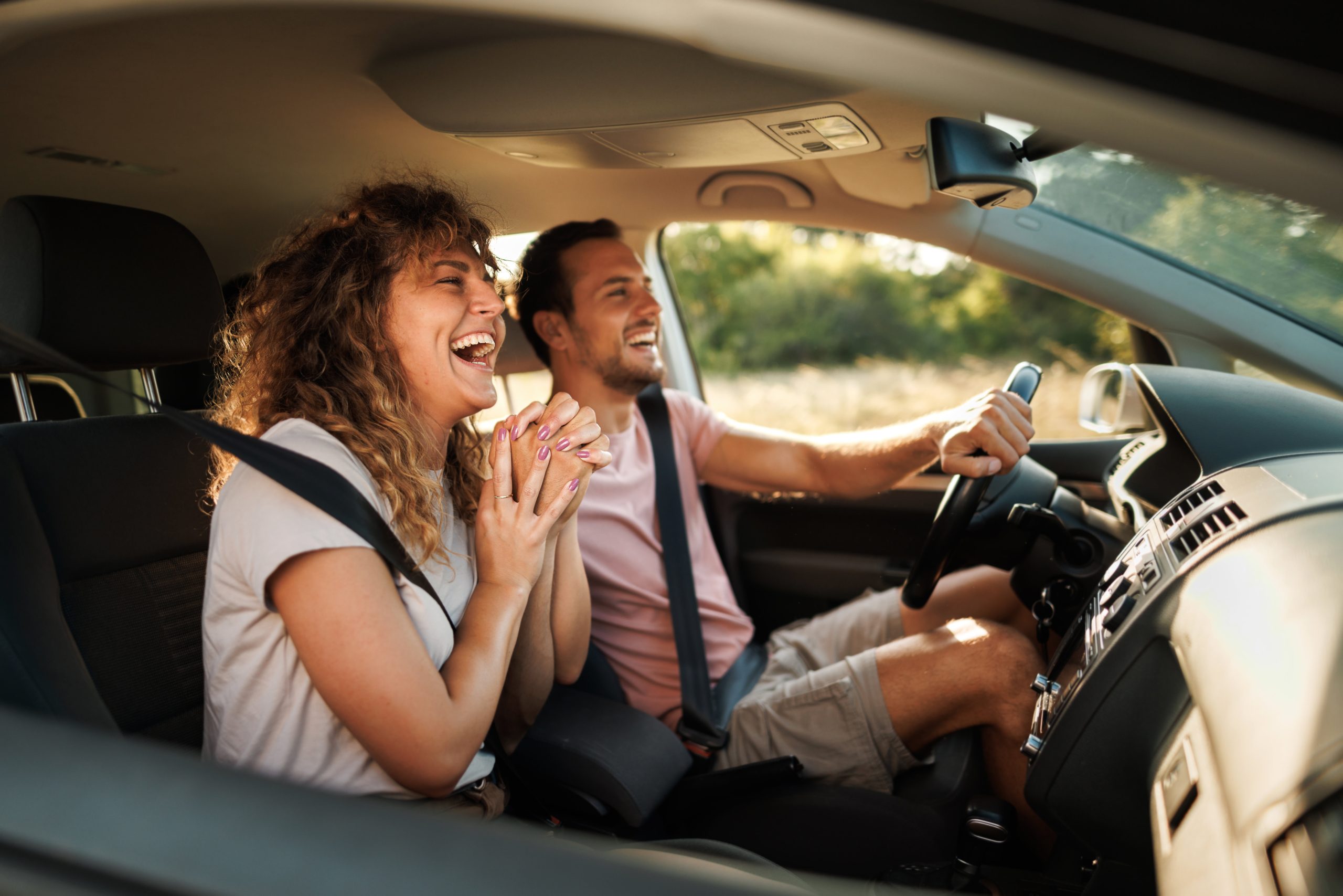 smiling man and woman in a car
