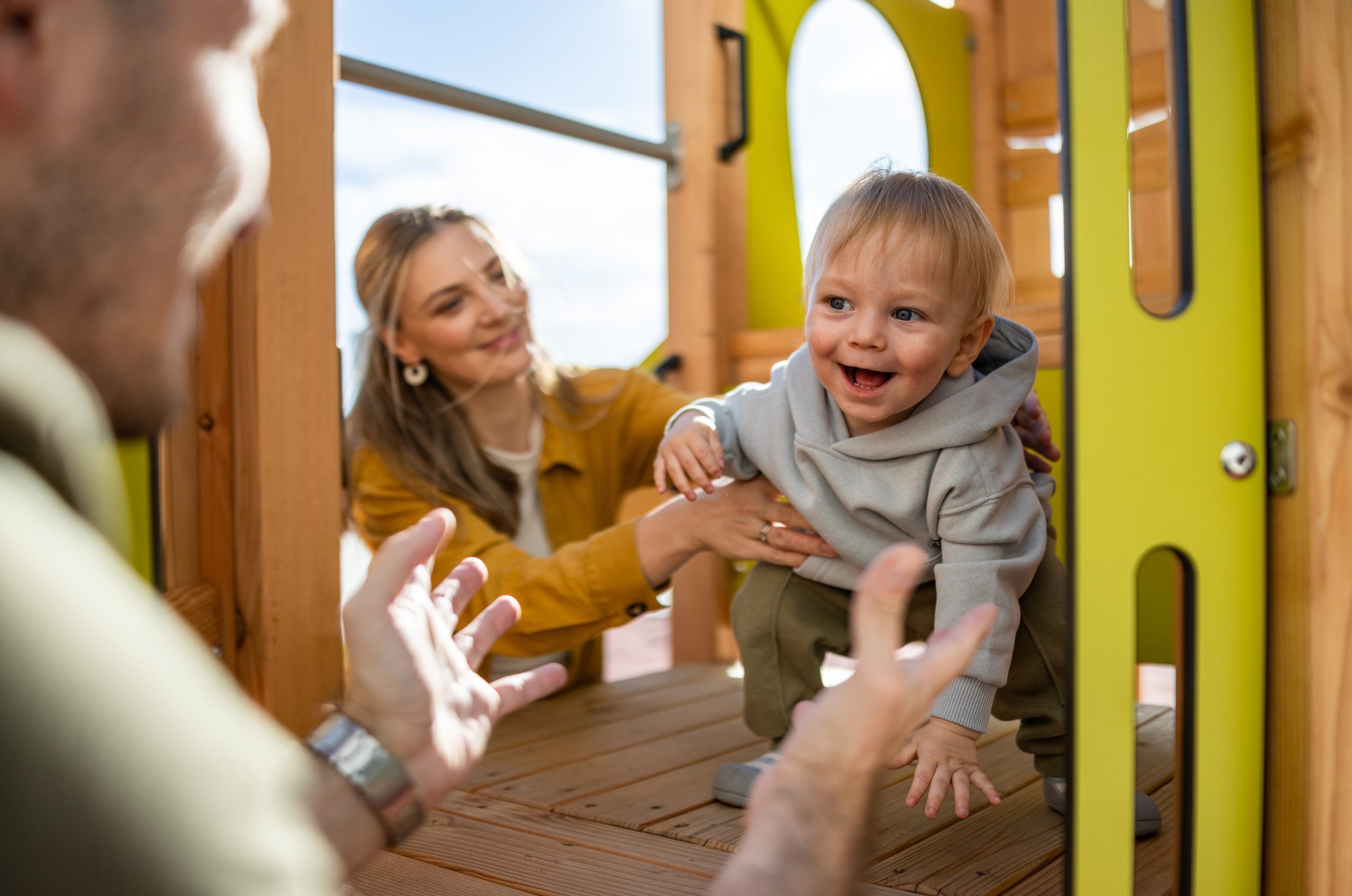  Candid snapshot of family happiness as parents bond with their toddler in an outdoor setting