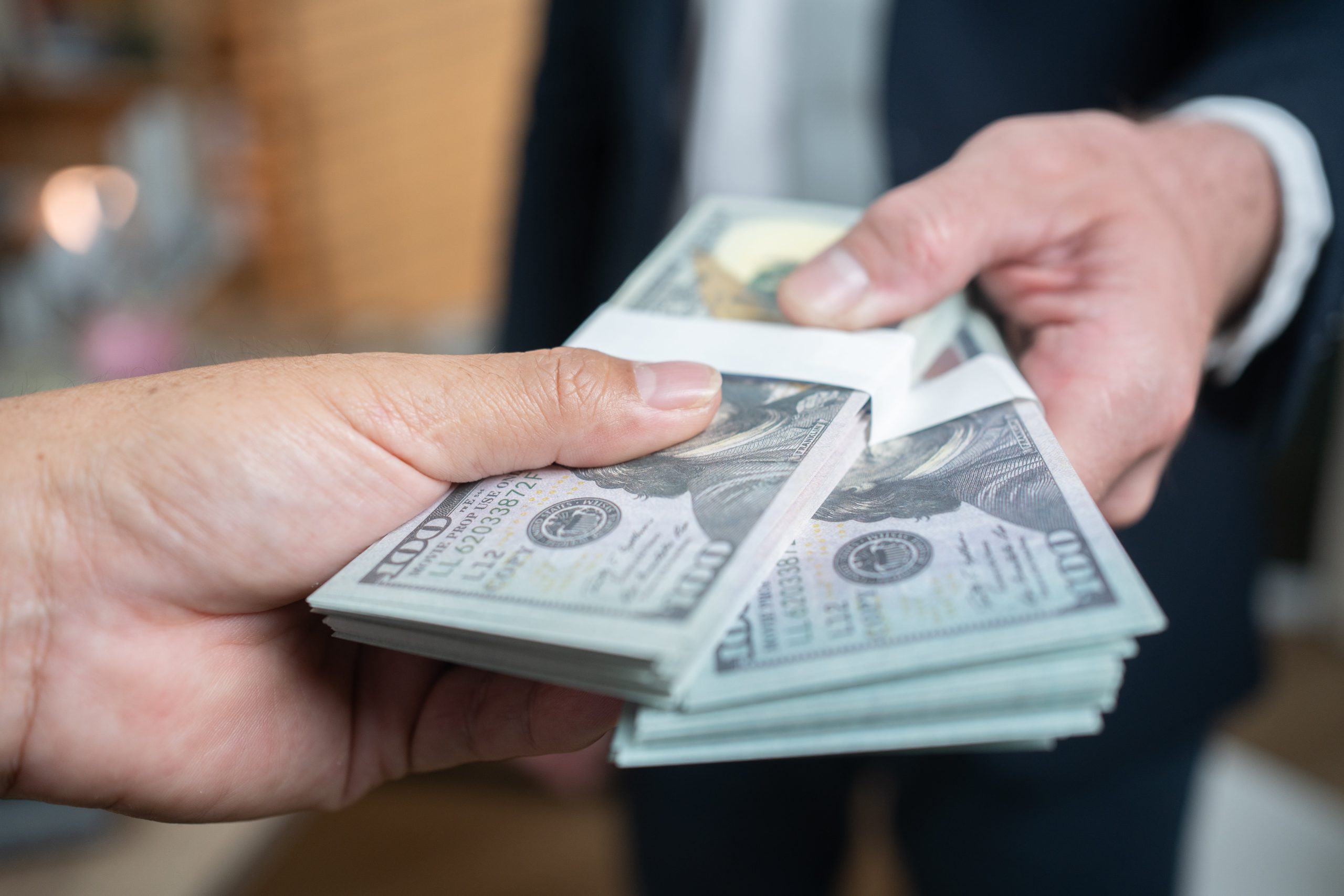 two people exchanging stacks of money